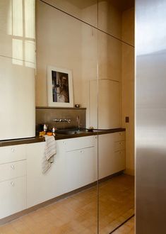 a kitchen with white cabinets and brown tile flooring