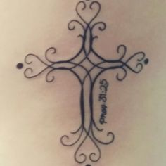 a cross tattoo on the back of a woman's stomach