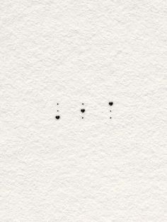 three black dots on white paper with one small dot in the middle and two smaller dots at the bottom