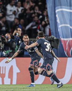 two soccer players are running on the field with their arms around each other as they celebrate