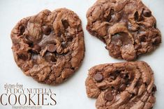 three chocolate cookies are sitting on a white surface with the words, fudge nutella cookies