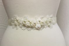 Floral Bridal Belt, Wedding Belt, Wedding Sash,  Wedding Belt,Ivory  Sash, Floral belt, Dress Belt Bridal Sash Belt  * 100% Handmade in United Kingdom*  WEDDING SASH BELT DETAILS Bridal sash, perfect for vintage inspired or one very romantic   wedding.  Lace accent size approx 8 x 2 inches. Applique colour: light ivory/ivory The elegant  ivory  lace is intricately beaded with  ivory faux pearls ,seed beads,  sequins,  mother of pearl flowers, crystal beads.A beautiful wedding sash that will compliment your bridal style! Satin ribbon in ivory, pale pink, dusky pink/peach or navy 25 mm available  ( 25mm x 260 cm), for you to tie a bow at the back . NOTE: please NOTE  in pictures mannequin is UK10 size only with small waist!  SIMPLE PACKAGING( as in stock at this moment). Matching headpiece a White Lace Wedding Sash, White Pearl Embellished Sashes For Wedding, Pearl Wedding Dress Belt, Lace Belt, Lace Sash, Pearl Wedding Dress, Bridal Business, Bridal Sash Belt, Wedding Dress Belt