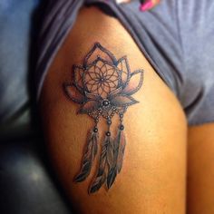 a woman's arm with a tattoo on it that has a dream catcher and feathers