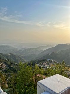 the sun is setting over some hills and valleys in the distance, with buildings on either side