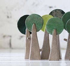 small trees made out of concrete with green and yellow discs in the middle, on top of each other