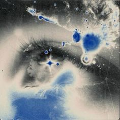 a woman's eye with blue bubbles in the center and stars around it, as if from outer space