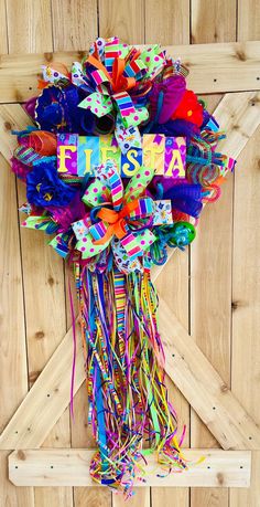 a bunch of colorful streamers hanging on the side of a wooden wall with words fiesta