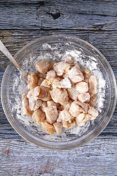 a bowl filled with powdered sugar on top of a wooden table