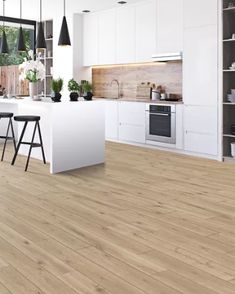 an open kitchen with white cabinets and wood flooring, along with bar stools