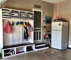 a white refrigerator freezer sitting inside of a kitchen next to a shelf filled with shoes