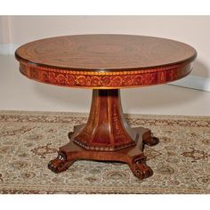 a round wooden table sitting on top of a rug