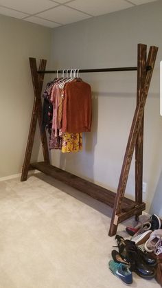 an empty room with shoes and clothing hanging on clothes racks next to the closet door