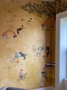 a room with a wall painted with children's drawings