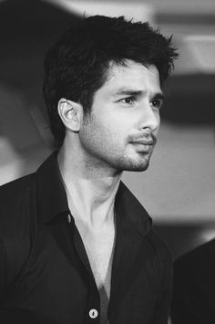 a black and white photo of a man with short hair looking to the side while wearing a shirt