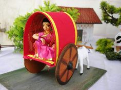 a doll is sitting in a toy carriage