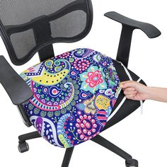 an office chair with a colorful patterned seat cover on it's back and arm rest