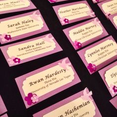 purple and white business cards with pink flowers on the front are arranged neatly in rows