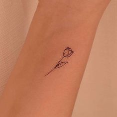 a small flower tattoo on the wrist, with a single line in the middle of it