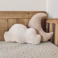 a white cloud pillow sitting on top of a wooden bed