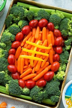 there are carrots, broccoli and tomatoes arranged in the shape of a football