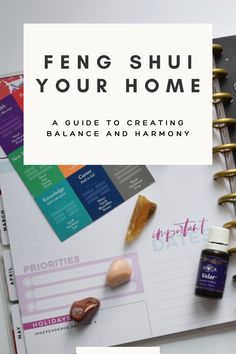 an open notebook with the title feng shui your home on it, surrounded by other items