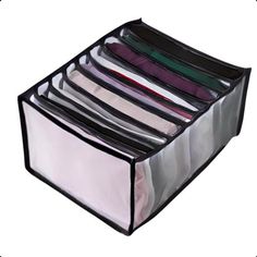 an open plastic storage box filled with lots of folded clothes and ties on top of each other