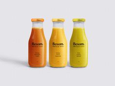 three bottles of juice are shown in this image, one is orange and the other is yellow