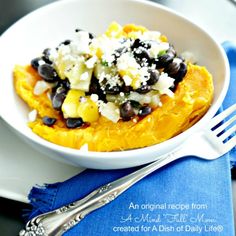 a white bowl filled with food on top of a blue napkin next to a fork