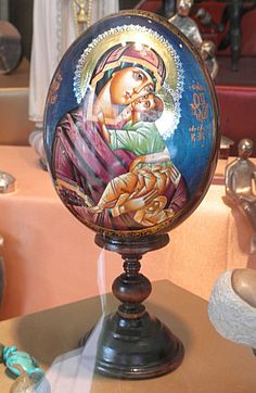 an image of the virgin mary and child jesus on top of a small globe in a shop window