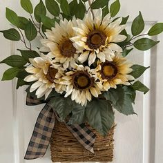 a basket filled with sunflowers on top of a wooden door handle and ribbon