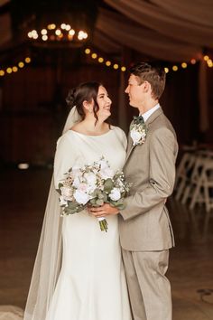 a bride and groom smile at each other