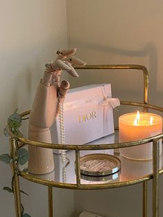 a candle, gift bag and other items on a gold stand