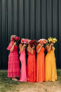 the bridesmaids are holding their bouquets and posing for a photo in front of a black wall