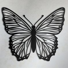 a metal butterfly on a white wall