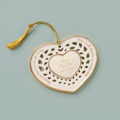 a heart shaped ornament with a tassel hanging from it's side