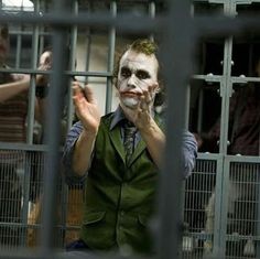 a man dressed as the joker behind bars