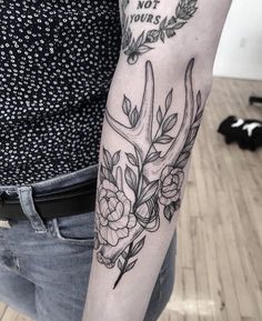 a woman's arm with flowers and antelope on it, which says not yours