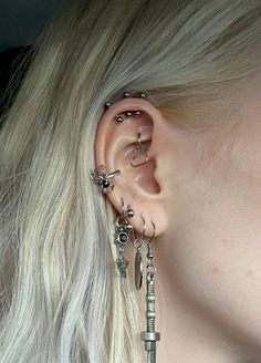 a close up of a person with ear piercings on their ears and behind the ear