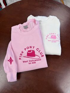 "Be part of the Pink Pony Club These are the cutest Pink Pony Club embroidered Chappells inspired sweaters! Right hand cuff in the corresponding color for a sleek finishing touch! Embroidered 7.00\"width Available in all colors shown on pictures Two designs (left chest / full chest) Crewnecks are super soft, cozy and comfortable! Sizes are unisex Material: 50% cotton / 50% polyester Weight: 8oz Pre-shrunk Polyester thread is used (won't shrink) Classic fit Gildan style 18000 Care: 💦 Machine was Pink Sweatshirt With Embroidered Logo For Spring, Pink Trendy Sweatshirt With Embroidered Logo, Pink Long Sleeve Sweater With Embroidered Logo, Pink Winter Sweatshirt With Embroidered Graphics, Trendy Pink Sweatshirt With Embroidered Logo, Winter Pink Sweatshirt With Embroidered Graphics, Pink Crew Sweatshirt With Embroidered Graphics, Pink Long Sleeve Sweatshirt With Embroidered Logo, Pink Crew Sweatshirt With Embroidered Logo