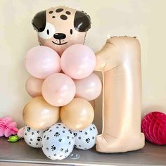 Cute puppy dog latex balloon tower for baby showers and birthday party decorations in rose, sand, coffee and cow print with flower and a coordinating number balloon 1st Bday Puppy Theme, Puppy Balloon Garland, 2nd Birthday Puppy Theme, Dog Themed 2nd Birthday Party, Lets Pawty Birthday Theme, Puppy Pinata