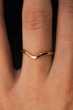 a woman's hand with a gold ring on it