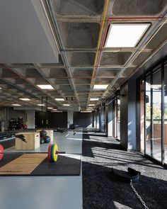 an empty gym with exercise mats and colorful balls on the floor in front of large windows