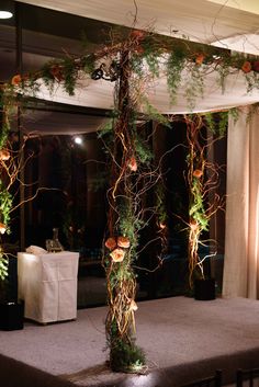 an arrangement of flowers and greenery is on display at a wedding reception in front of a window