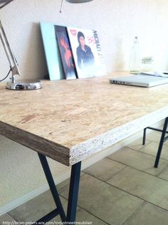 a wooden table with two pictures on it and a laptop computer sitting on top of it