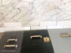 three pieces of metal sitting next to each other in a room with marble walls and flooring