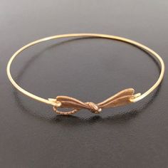 "Dragonfly Bracelet Bangle - There's nothing like a dragonfly buzzing by your boat when you're out on the lake, and then it lands on the oar! A gold tone dragonfly charm will be transformed into a dainty & delicate dragonfly bangle bracelet with bangle band choice of brass or 14k gold filled. Also available in silver tone with bangle band choice of silver filled or sterling silver. This nature inspired jewelry piece looks great stacked with other bangles from my collection. Have fun stacking Adjustable Gold Dragonfly Jewelry, Adjustable Dragonfly Jewelry With Lobster Clasp, Women Nature, Dragonfly Bracelet, Jewelry Nature, Dragonfly Jewelry, Dragonfly Charm, Insect Jewelry, Dragon Fly