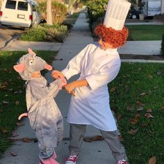 two children dressed up as mice and one is wearing a chef's hat while holding hands