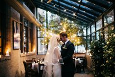 a bride and groom standing in front of a table with candles on it at their wedding reception