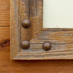 an old wooden frame with metal knobs on it