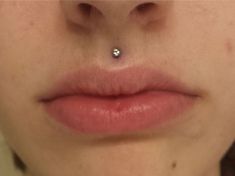 a woman with a nose piercing on her lip